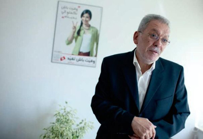 Kamel Jendoubi devant l'affiche des élections de 2011.