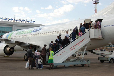  Un groupe de réfugiés embarque dans un avion à l’aéroport de Djerba, afin de gagner leur pays de réinstallation, l’Allemagne. 